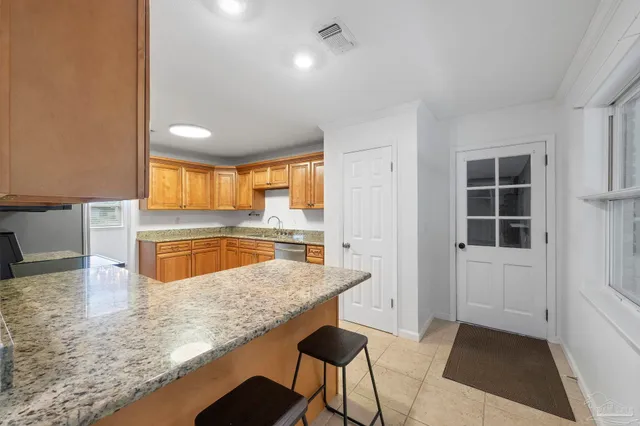 a kitchen with stainless steel appliances granite countertop a sink and a white cabinets