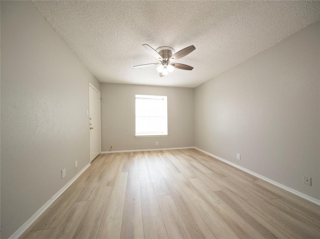 1717 North Locust Street, Unit 5 Denton, TX 76201 - Photo 3 of 11 an empty room with wooden floor and windows