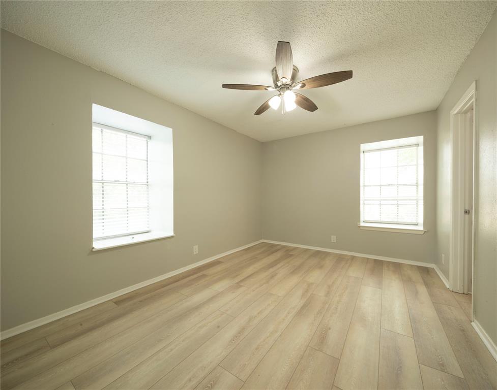 1717 North Locust Street, Unit 5 Denton, TX 76201 - Photo 7 of 11 a view of an empty room with wooden floor and a window