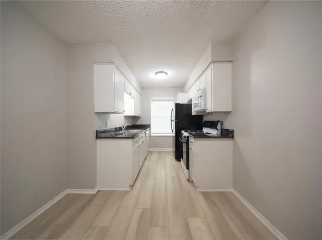 a kitchen with a refrigerator a stove top oven a sink and dishwasher