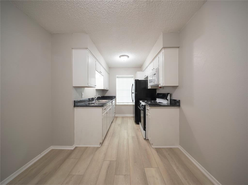 1717 North Locust Street, Unit 5 Denton, TX 76201 - Photo 10 of 11 a kitchen with a refrigerator a stove top oven a sink and dishwasher
