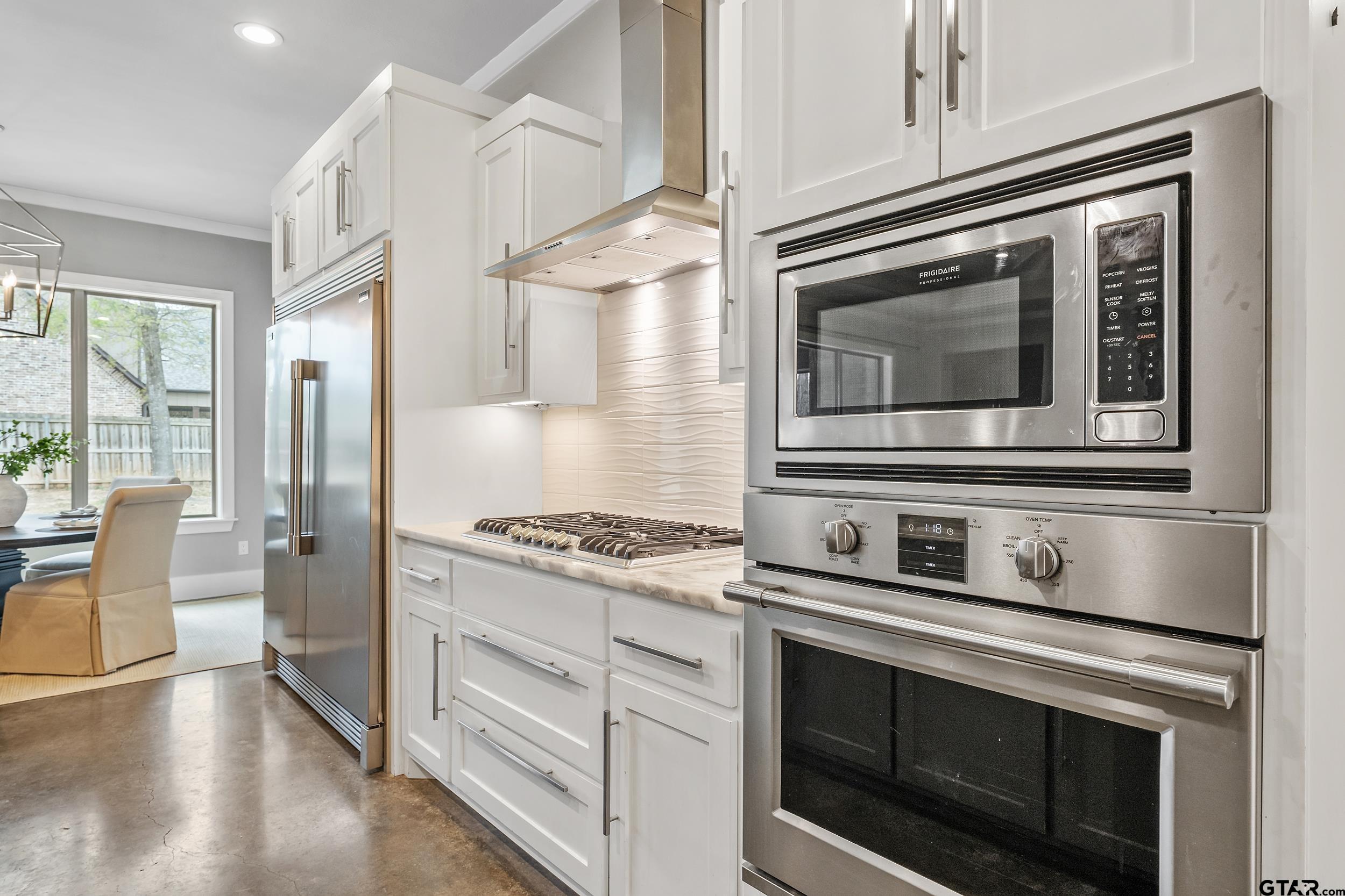 1569 Cooks Crossing Tyler, TX 75703 - Photo 11 of 39 a kitchen with granite countertop cabinets stainless steel appliances and wooden floor