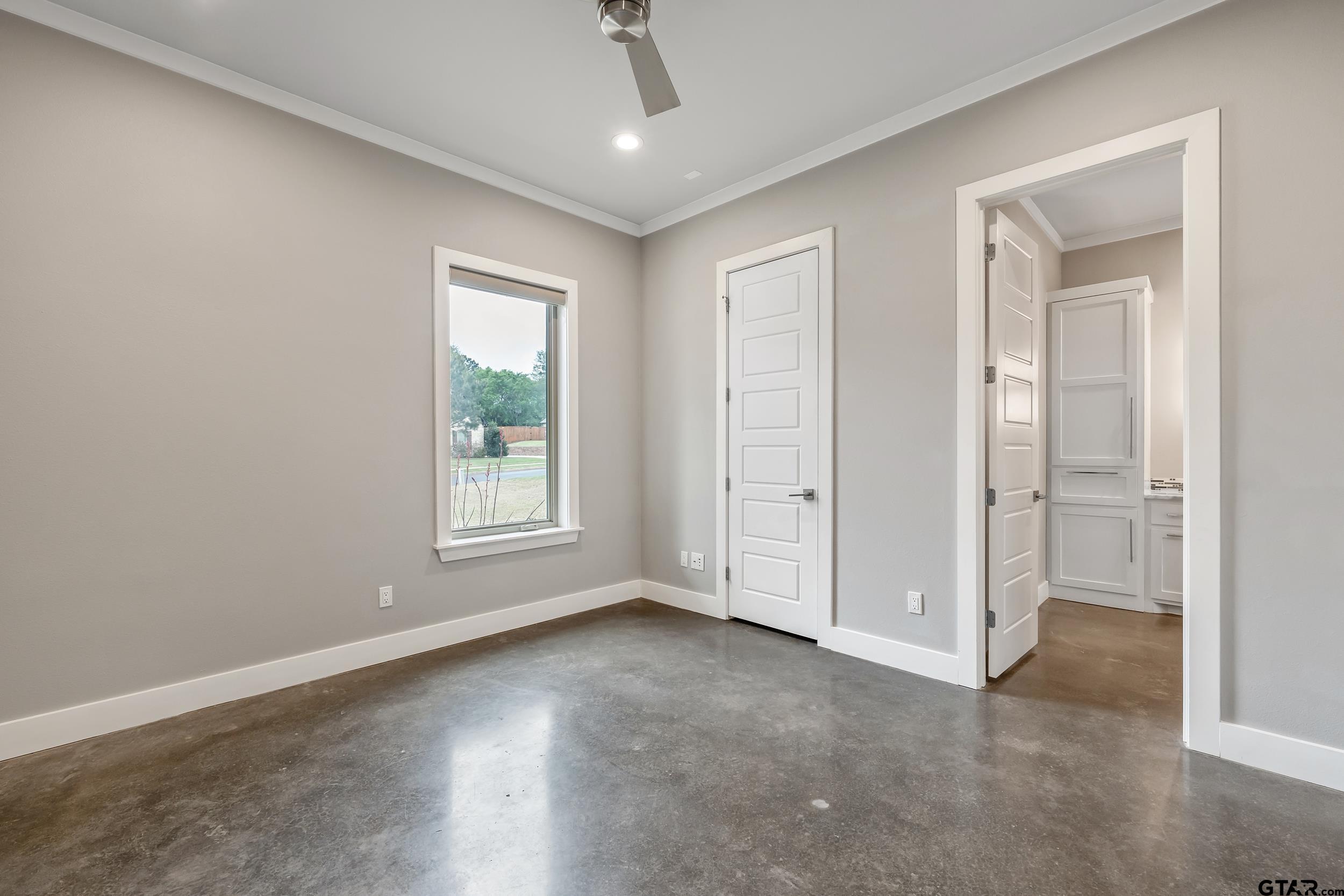 1569 Cooks Crossing Tyler, TX 75703 - Photo 30 of 39 an empty room with wooden floor cabinet and windows