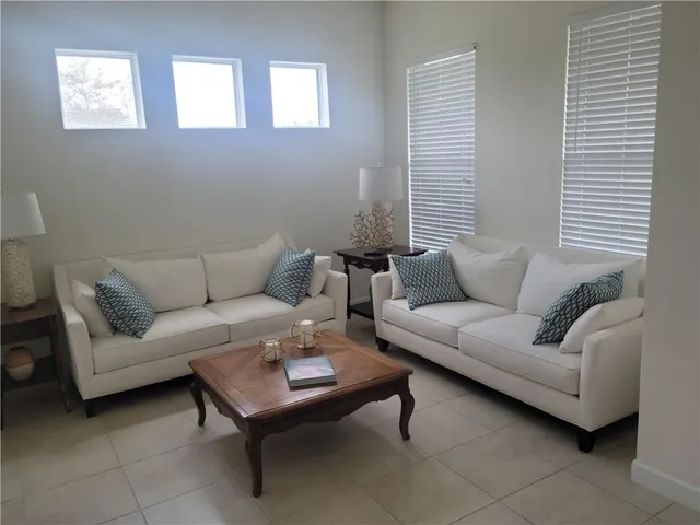 a living room with furniture a rug and a window