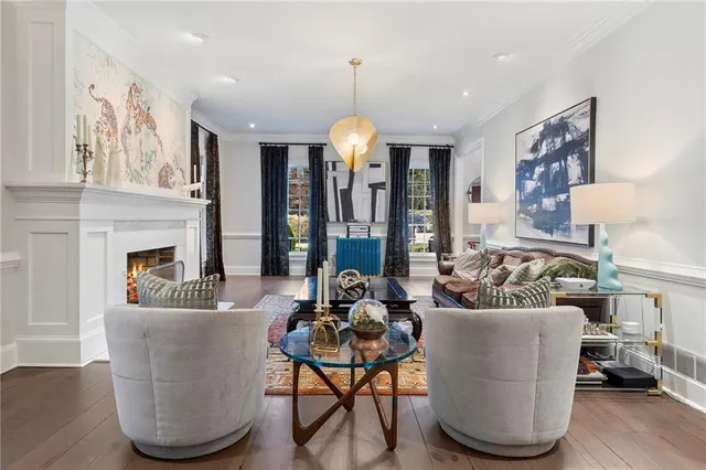a living room with furniture a fireplace and a chandelier