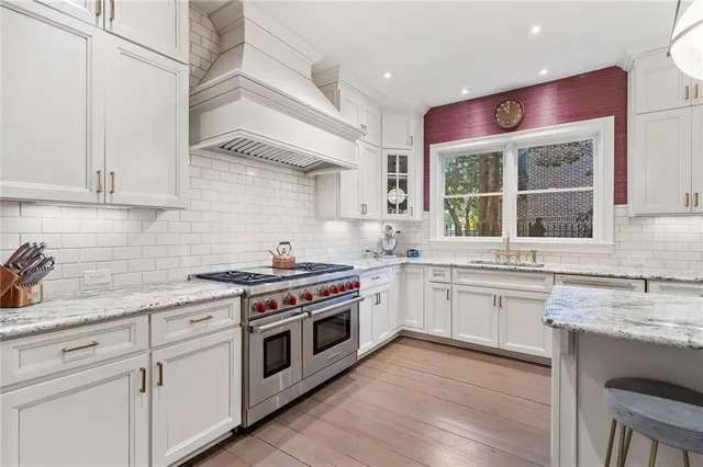 a kitchen with kitchen island granite countertop a sink cabinets and wooden floor