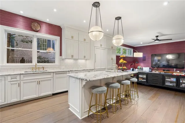 a kitchen with stainless steel appliances granite countertop a stove a sink a refrigerator and cabinets with wooden floor