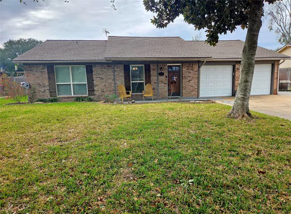 front view of a brick house with a yard