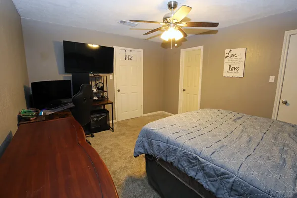 a bedroom with a bed and a flat screen tv