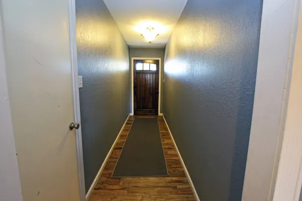 a view of a hallway with wooden floor