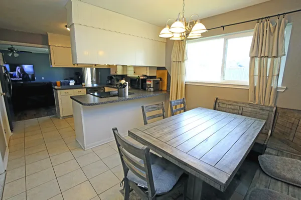 a kitchen with a table chairs and a refrigerator