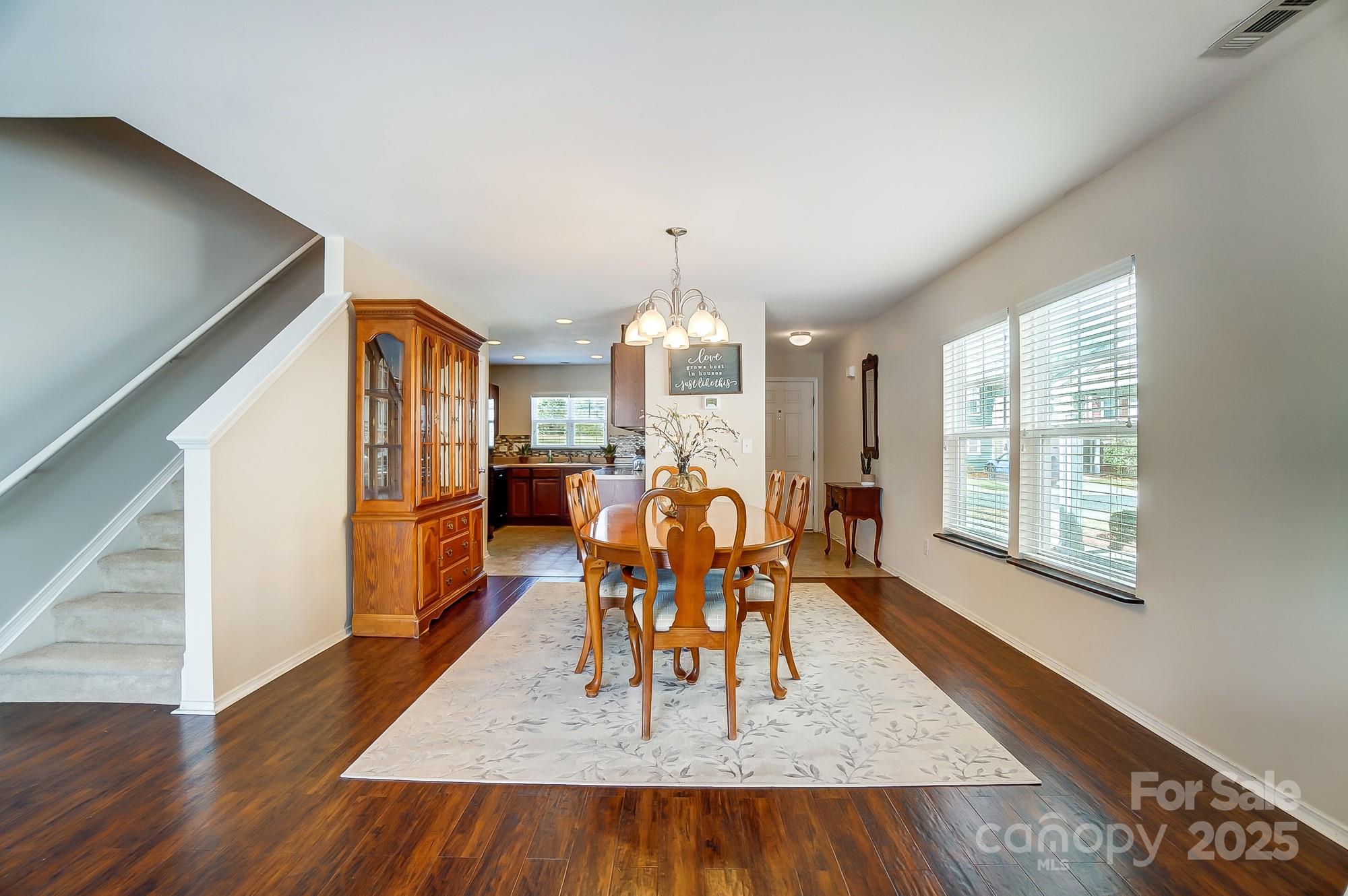 309 River Clay Road Fort Mill, SC 29708 - Photo 11 of 35 a dining room with wooden floor a chandelier a wooden table and chairs