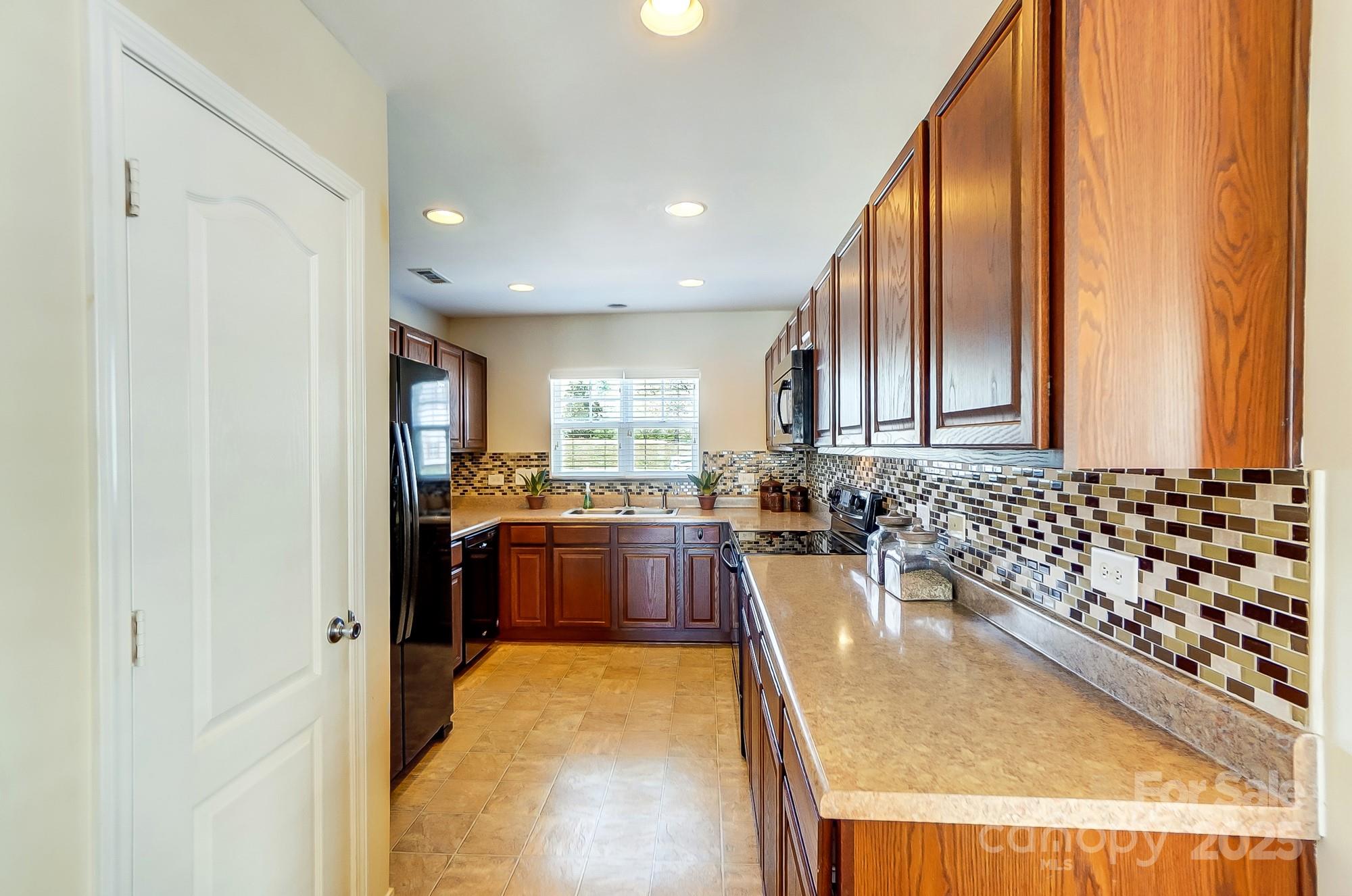 309 River Clay Road Fort Mill, SC 29708 - Photo 18 of 35 a large kitchen with kitchen island granite countertop a large window and stainless steel appliances