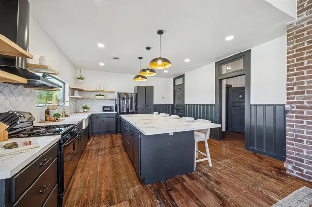 a kitchen with stainless steel appliances granite countertop a stove a sink and a refrigerator