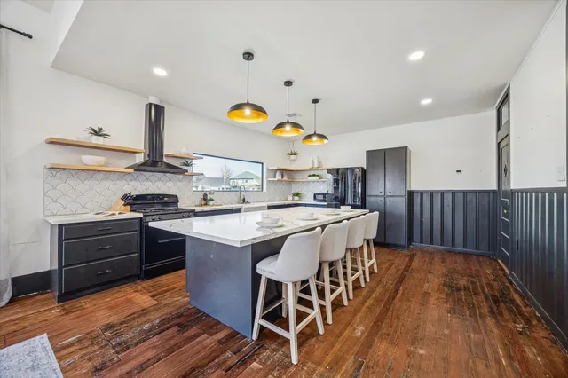 a kitchen with stainless steel appliances granite countertop a stove a sink dishwasher and a wooden cabinets