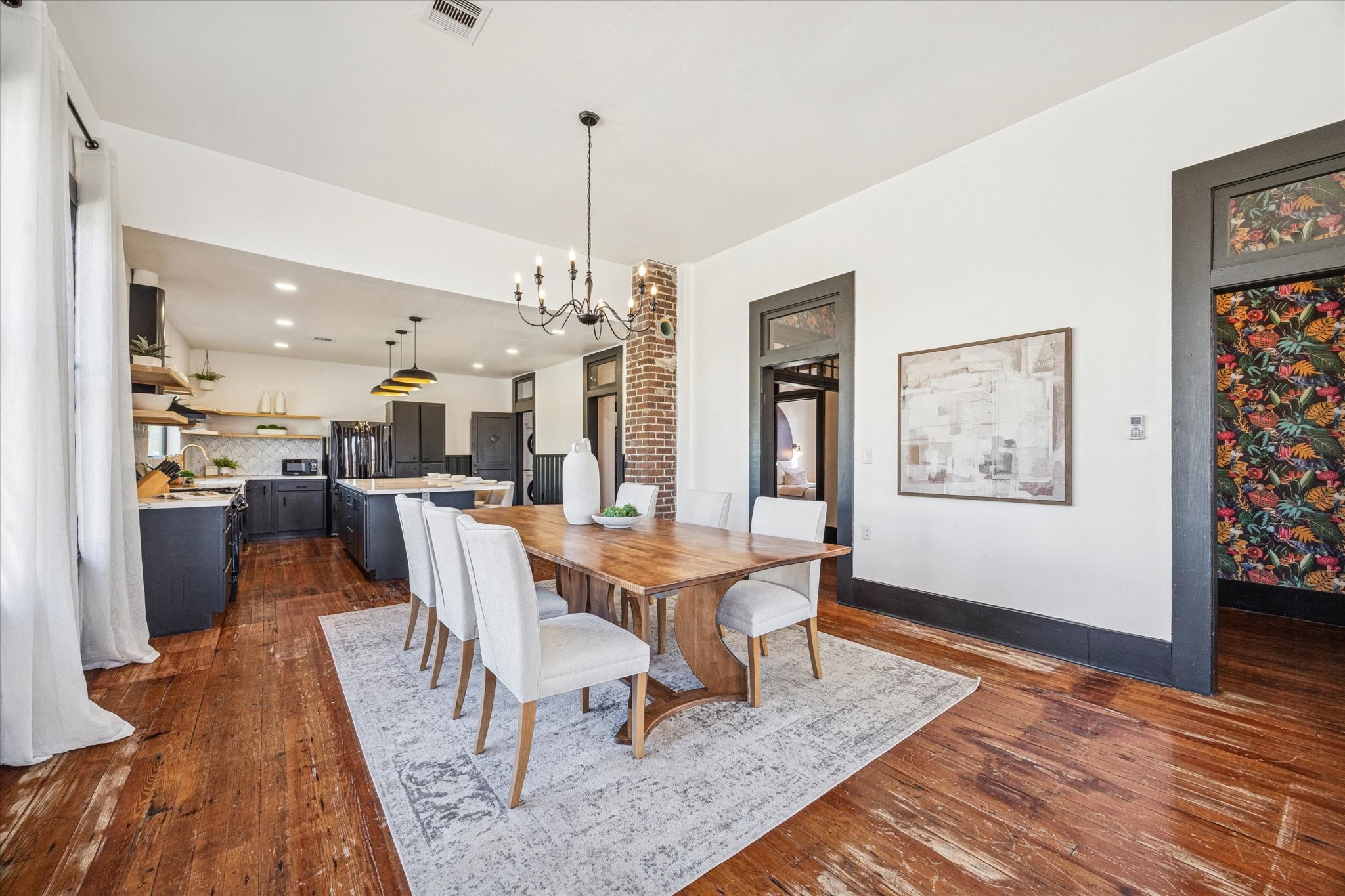 1920 Fulton Street Houston, TX 77009 - Photo 8 of 39 a view of a dining room and livingroom with furniture wooden floor a rug a painting and a chandelier