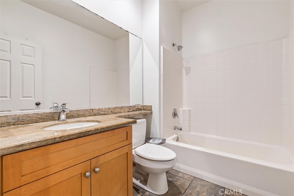 119 Jadestone Irvine, CA 92603 - Photo 15 of 27 a bathroom with a granite countertop toilet a sink and a bathtub