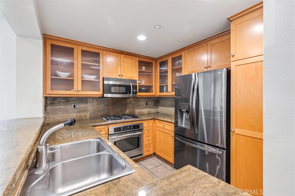 119 Jadestone Irvine, CA 92603 - Photo 8 of 27 a kitchen with stainless steel appliances granite countertop a refrigerator and a sink