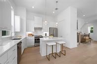 4619 Maxie Street Houston, TX 77007 - Photo 22 of 45 a kitchen with stainless steel appliances granite countertop a stove top oven a sink dishwasher a dining table and chairs with wooden floor