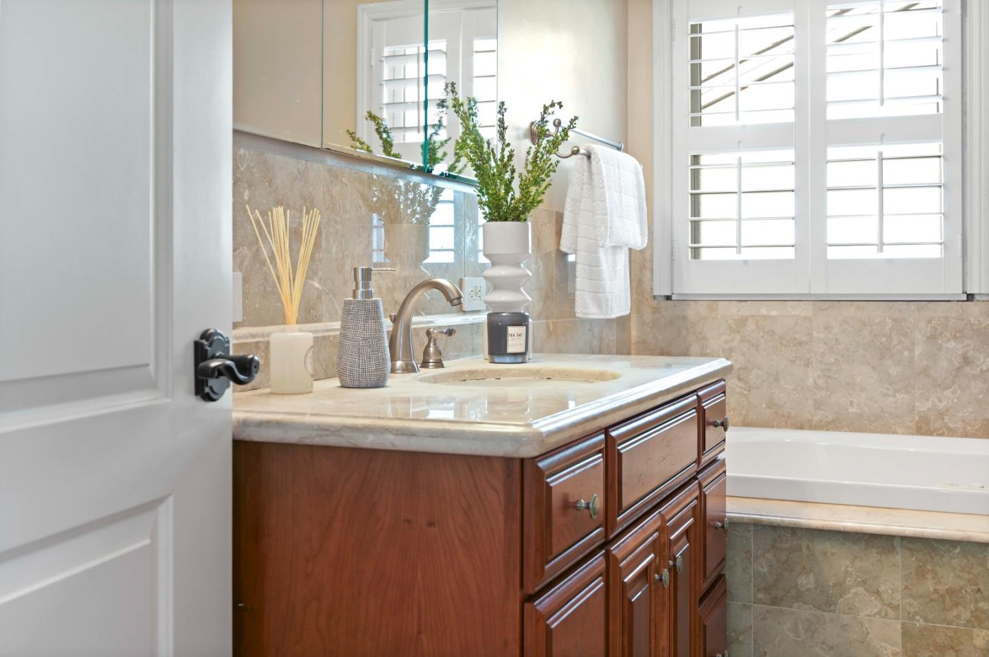 754 26th Avenue San Mateo, CA 94403 - Photo 19 of 57 a bathroom with a granite countertop sink a large mirror a vanity and a bathtub next to a window