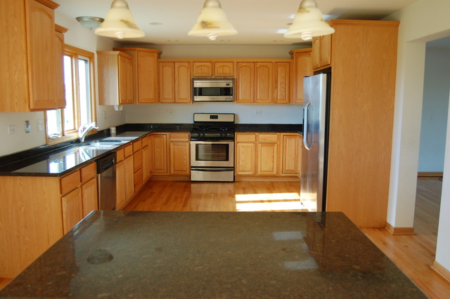 4975 Cardinal Court Monee, IL 60449 - Photo 3 of 9 a kitchen with stainless steel appliances granite countertop a stove a sink and a refrigerator