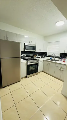 a kitchen with stainless steel appliances granite countertop a stove a sink dishwasher and a refrigerator