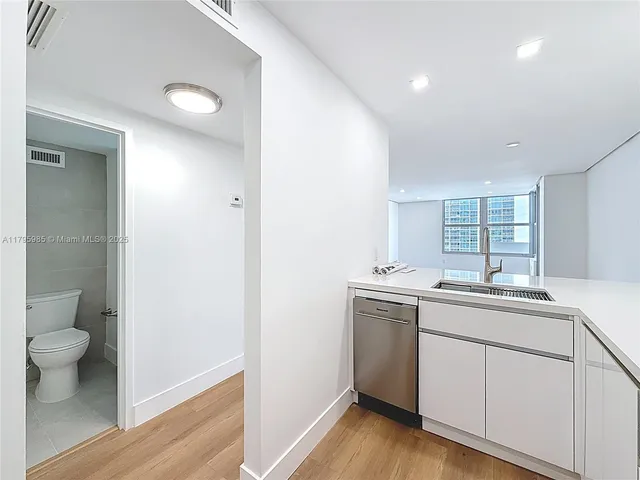 a view of a kitchen with a sink and wooden floor