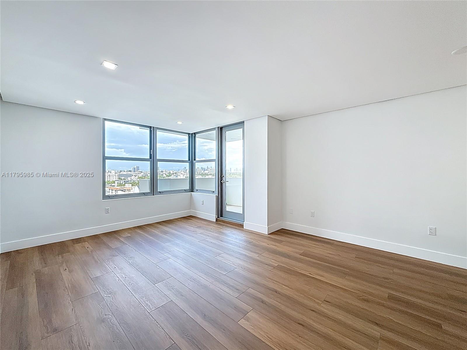 2899 Collins Avenue, Unit 1218 Miami Beach, FL 33140 - Photo 15 of 41 an empty room with wooden floor and windows