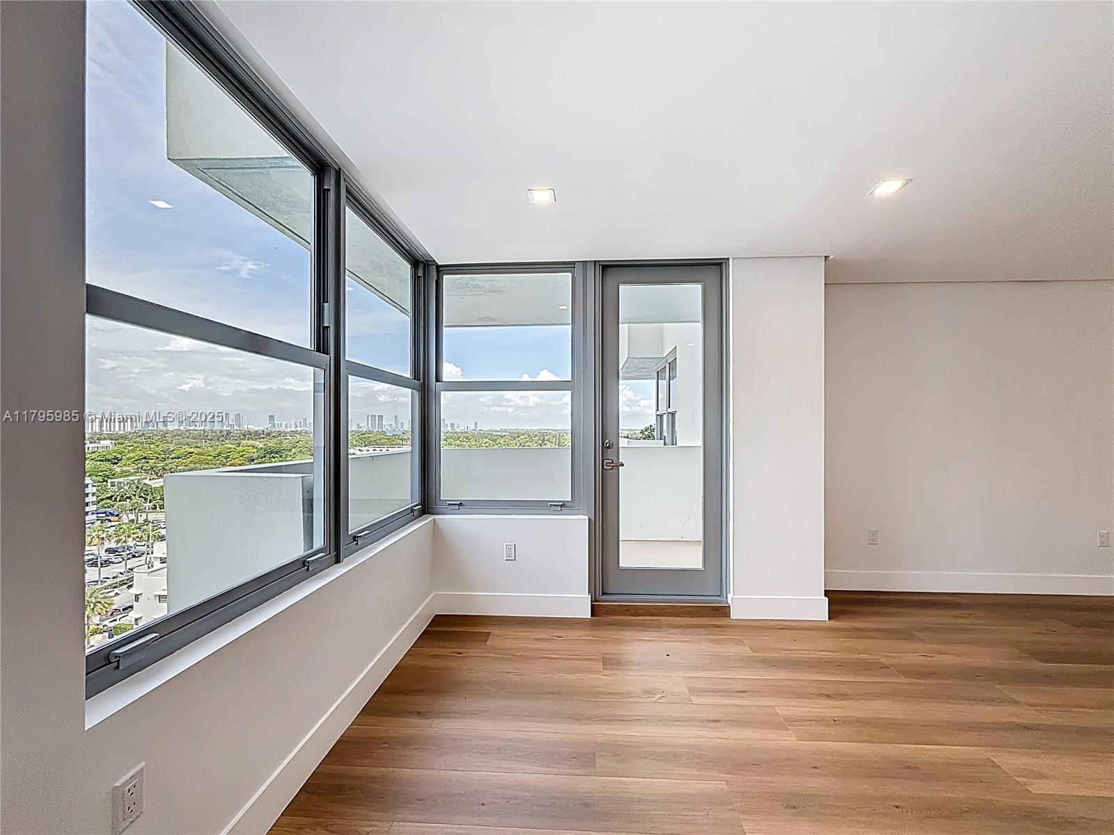 2899 Collins Avenue, Unit 1218 Miami Beach, FL 33140 - Photo 16 of 41 a view of an empty room with wooden floor and a window