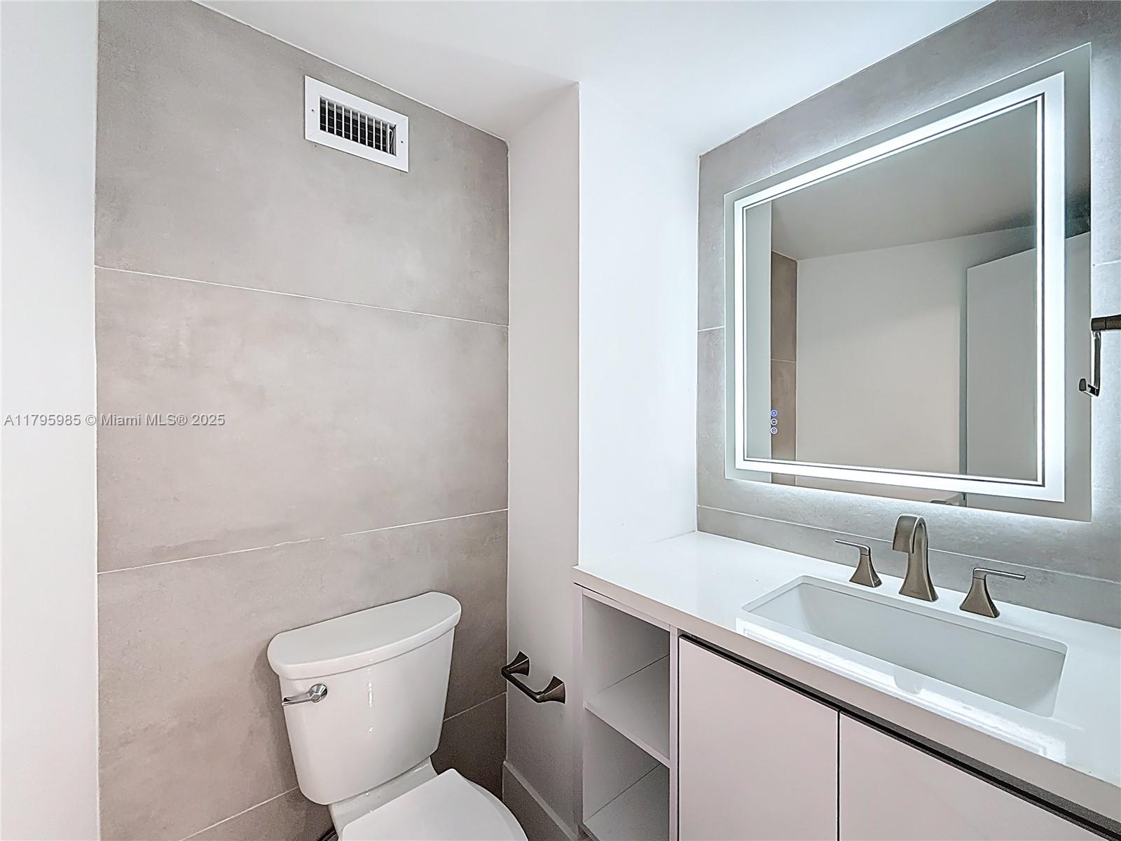 2899 Collins Avenue, Unit 1218 Miami Beach, FL 33140 - Photo 19 of 41 a bathroom with a toilet sink and mirror
