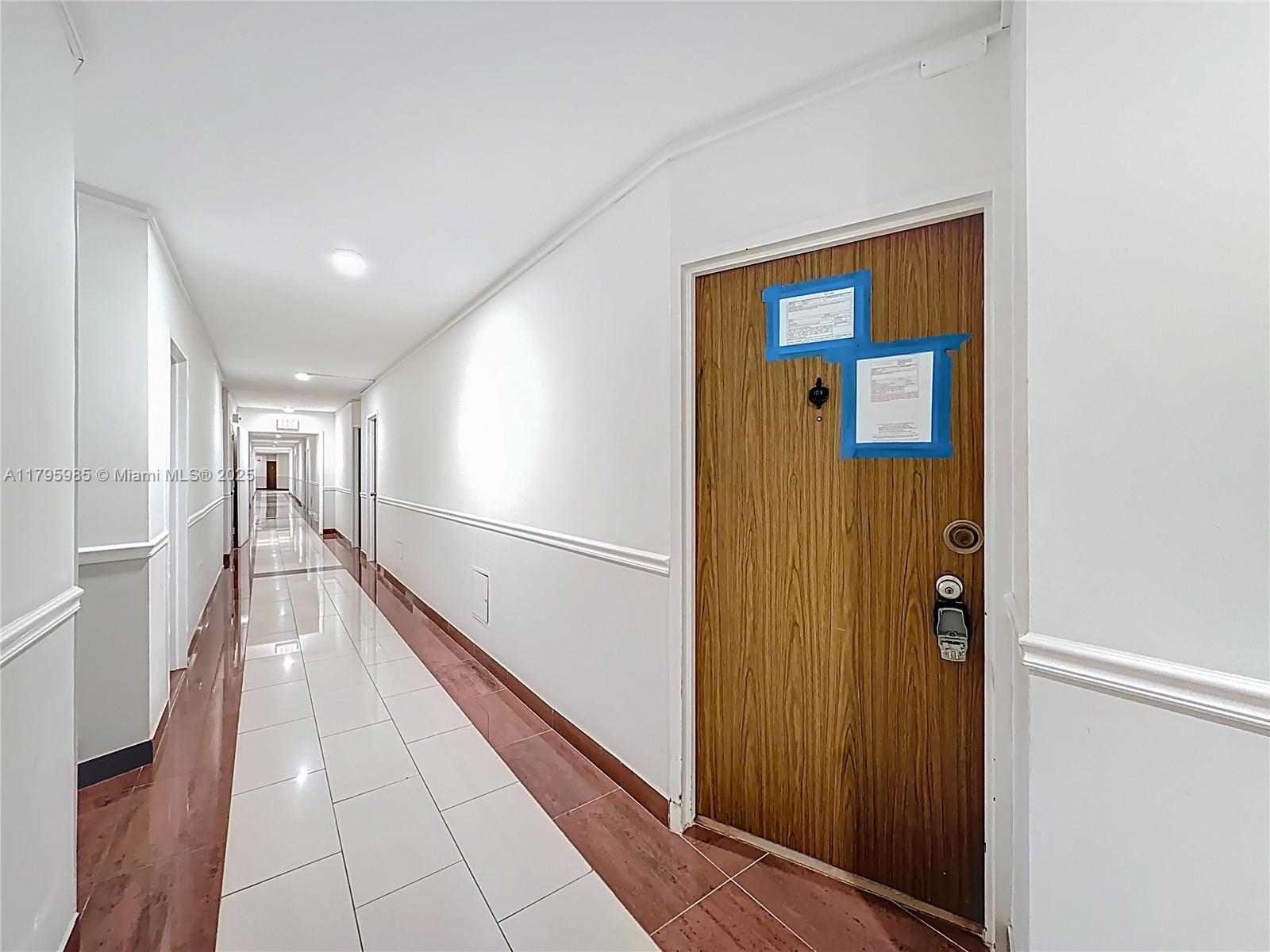2899 Collins Avenue, Unit 1218 Miami Beach, FL 33140 - Photo 5 of 41 a hallway with wooden floor and staircase