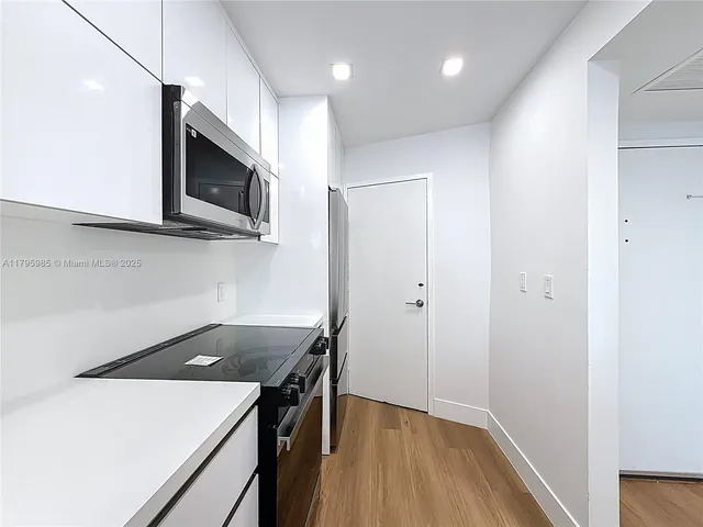 a kitchen with a sink a microwave and cabinets