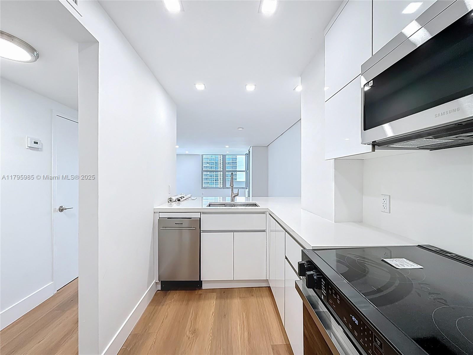 2899 Collins Avenue, Unit 1218 Miami Beach, FL 33140 - Photo 9 of 41 a kitchen with a sink appliances and cabinets