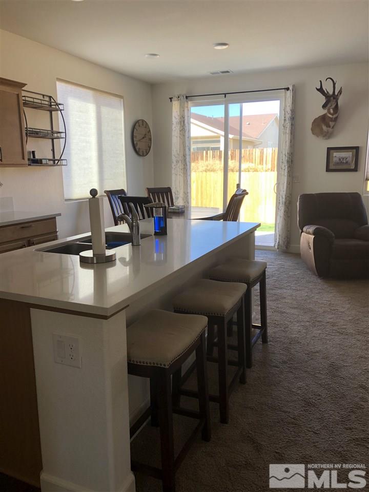 9329 Lagoon Court Reno, NV 89506 - Photo 5 of 15 a kitchen with granite countertop a table chairs stove and sink