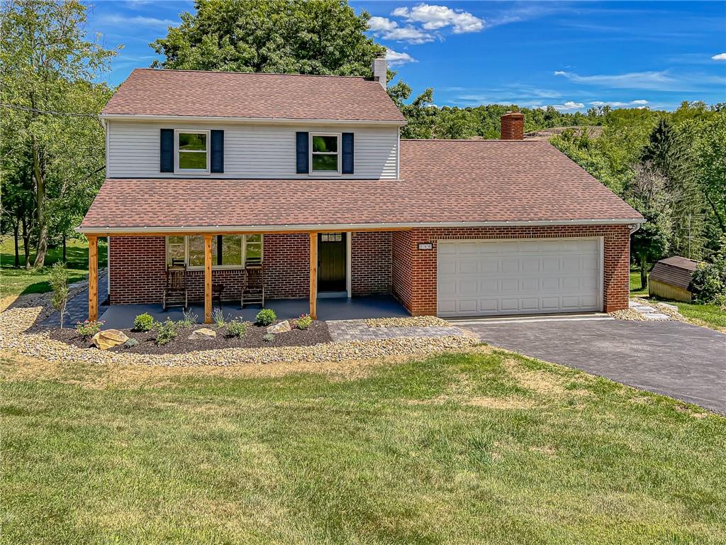 a front view of a house with a garden