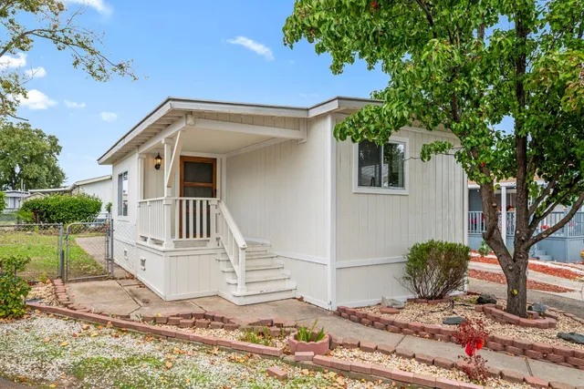 a view of a house with a yard and potted plants