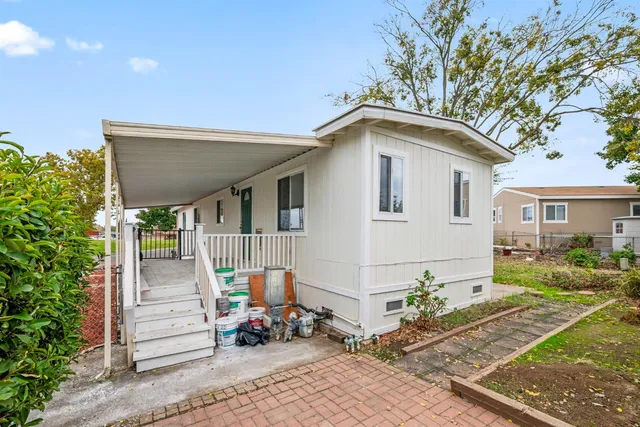 a view of a house with a yard and potted plants