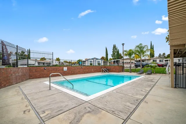 a view of a swimming pool with a yard and plants