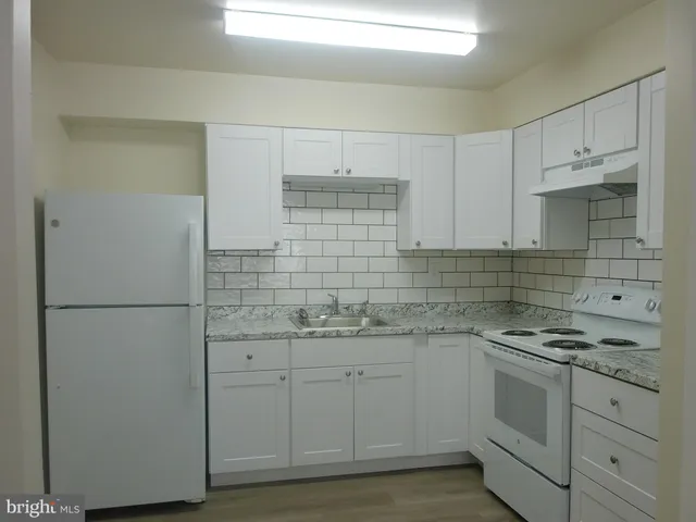 a kitchen with white cabinets stainless steel appliances and sink