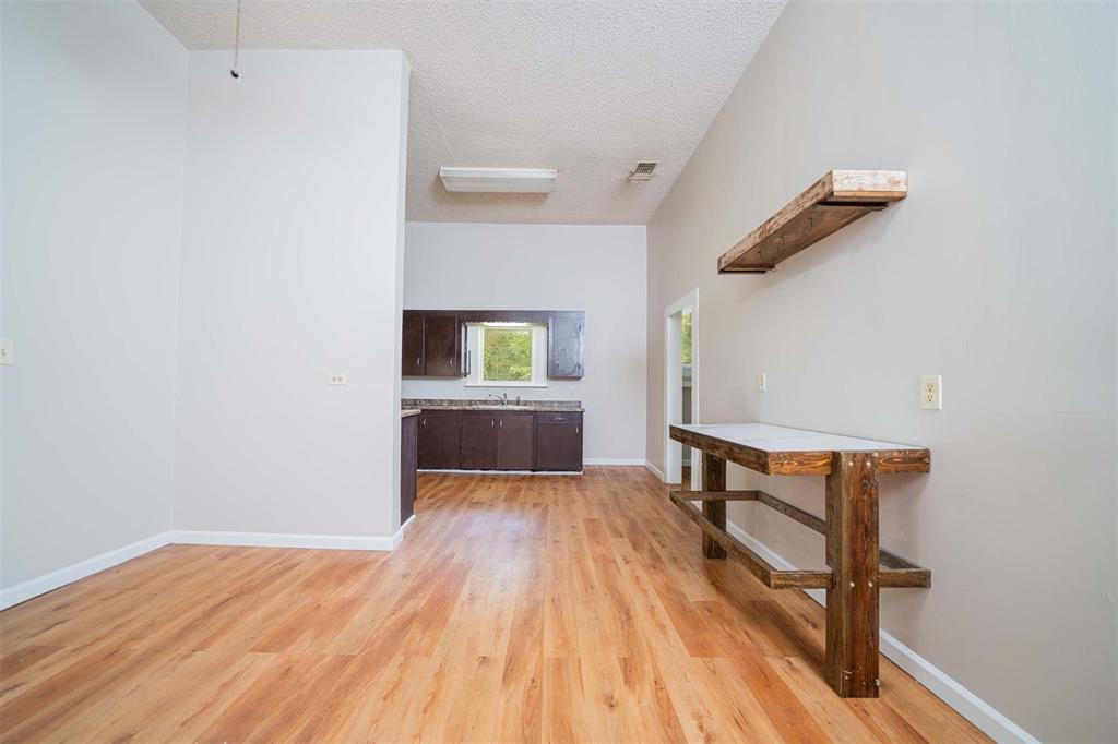 100 West Groves Street Big Sandy, TX 75755 - Photo 11 of 30 an empty room with wooden floor and windows