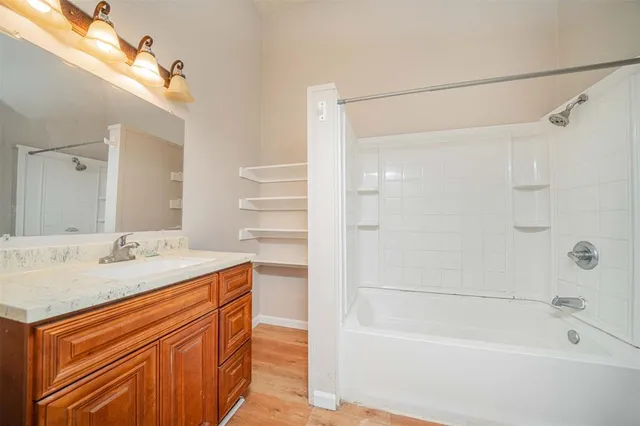 a bathroom with a granite countertop sink mirror toilet and bathtub
