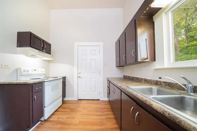 a kitchen with stainless steel appliances granite countertop a sink stove and cabinets