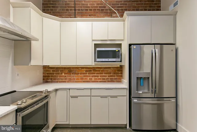 a kitchen with granite countertop white cabinets and stainless steel appliances