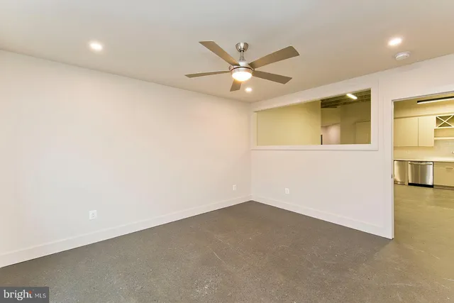 an empty room with a ceiling fan and a window