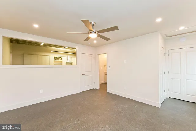 an empty room with a ceiling fan and a window