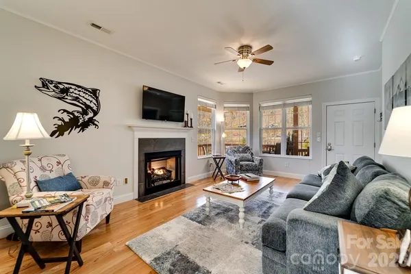 a living room with furniture a fireplace and a flat screen tv