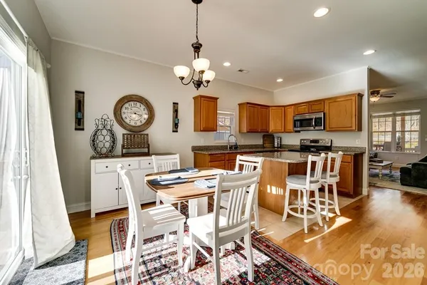 a view of a dining room and livingroom with furniture wooden floor and a clock