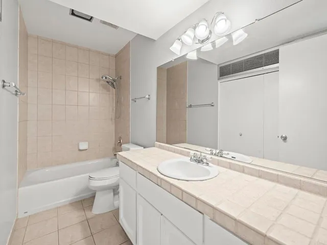 a bathroom with a granite countertop sink a toilet and shower