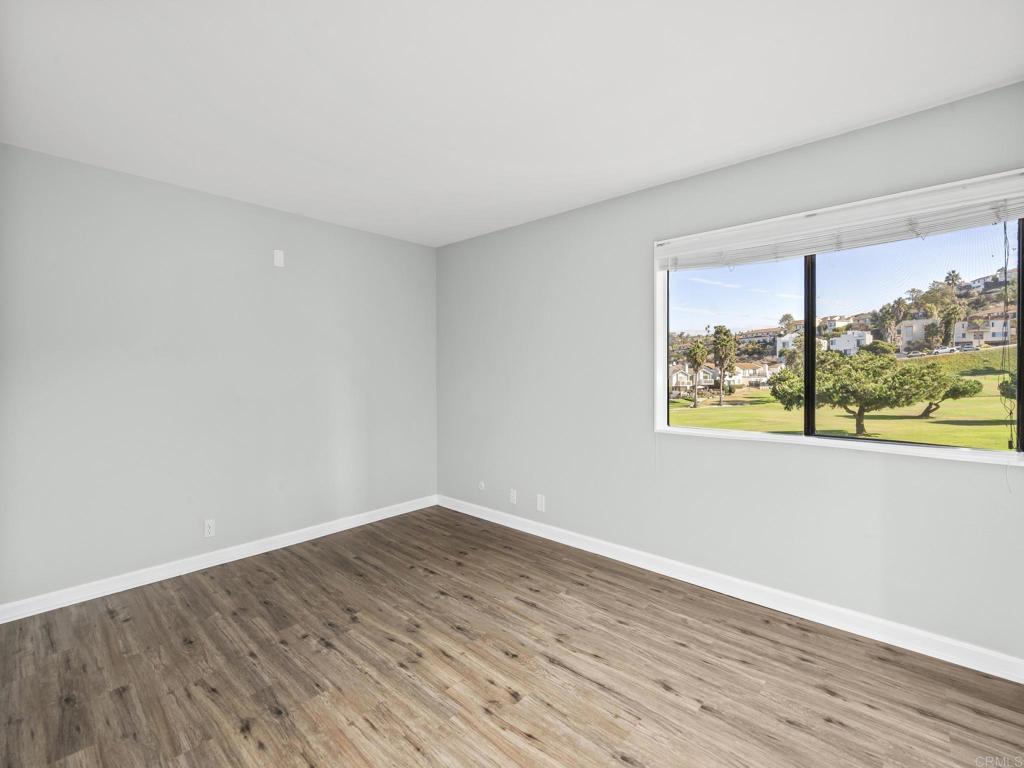 2639 Pirineos Way, Unit 231 Carlsbad, CA 92009 - Photo 15 of 34 a view of an empty room with wooden floor and a window
