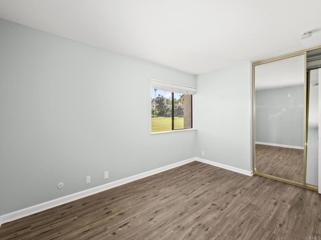 2639 Pirineos Way, Unit 231 Carlsbad, CA 92009 - Photo 16 of 34 a view of an empty room with wooden floor and a window